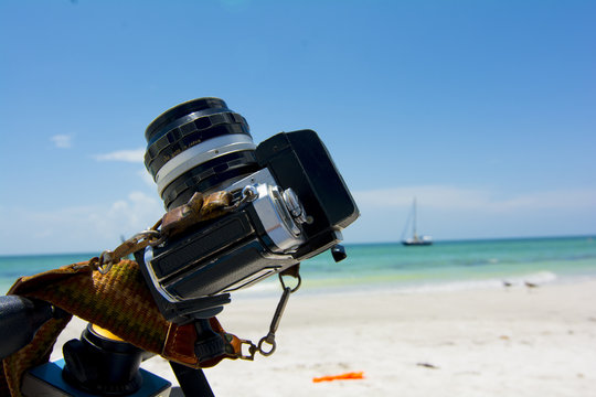 film camera shooting solar eclipse at beach 