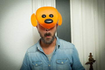 crazy guy making funny face wearing orange dog mask