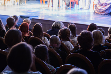 The audience in the theater watching a play. The audience in the hall: adults and children.