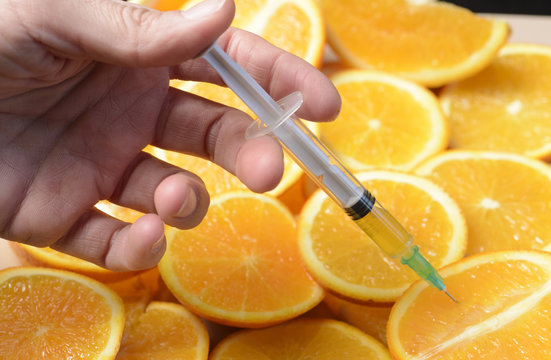 Vitamin C. Orange in a Cut and a Syringe With Vitamin C. 