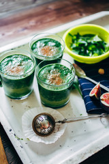 From above crop shot of green smoothies with leaves of fresh mint on the kitchen desk