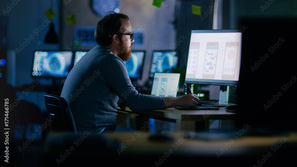 Poster Male Mobile Application Developer Works with Graphics on His Personal Computer with Two Monitors. He Works Late at Night, in an Empty Office.