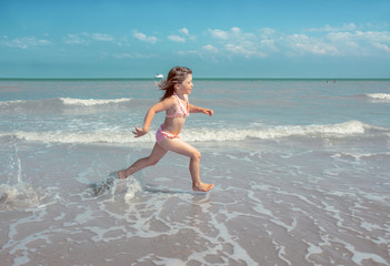 Fototapeta na wymiar enfant jouant sur la plage