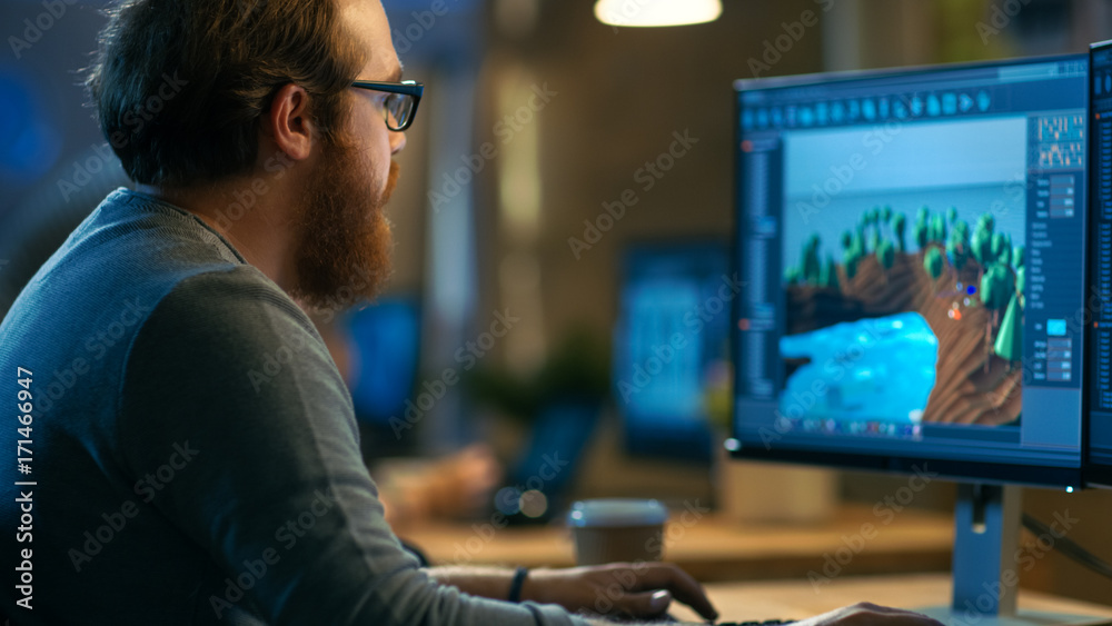 Poster male game developer works on a new level design. he's handsome bearded man with glasses and works in