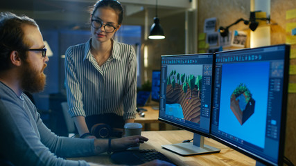Obraz premium Male Game Developer Talks with Artistic Female Level Designer. Two Displays Show Totally Original Game. They Work in a Creative Office Loft.