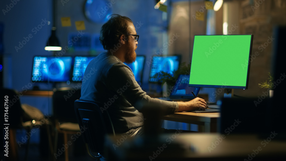 Poster Creative Bearded Man Works on a Personal Computer with Isolated Mock-up Green Screen. He Works Alone in the Office Late at Night.
