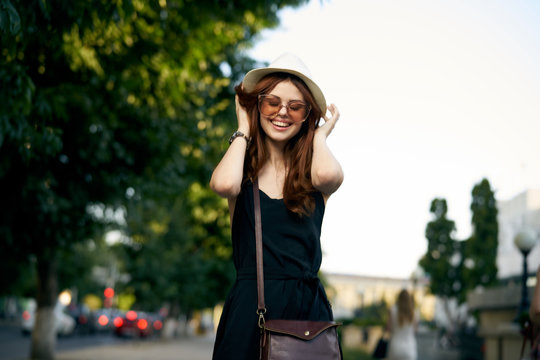 woman in sunglasses smiling, hat, street