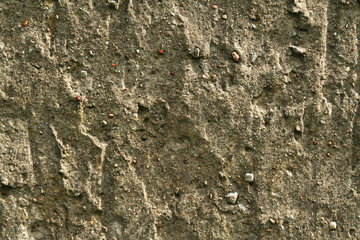 old concrete wall destroyed from rain and water with rinsed, visible stones