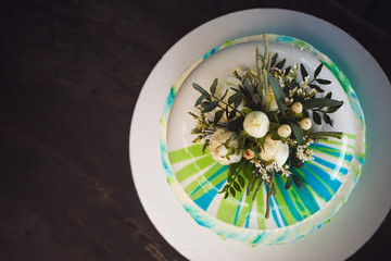 Birthday cake decorated by flowers on wood background
