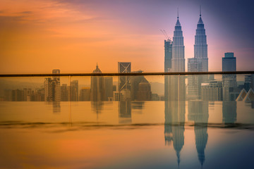 Fototapeta na wymiar Cityscape of Kuala lumpur city skyline with swimming pool on the roof top of hotel at sunrise in Malaysia.