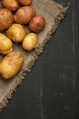 Potatoes on a black wooden background