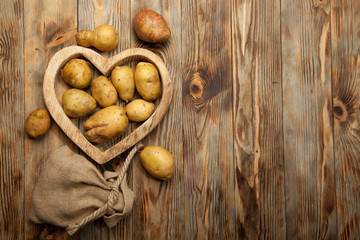 Bunch of potatoes on wooden background close up shoot
