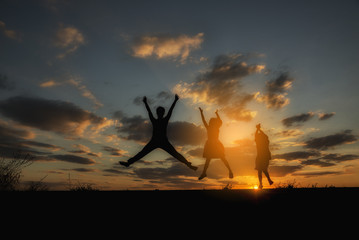 Silhouette of mother and kids.Happy family in mother's day concept,I Love you mom.Asian mother and little cute daughter playing together.Mother,daughter and son greeting,jumping together with sunset