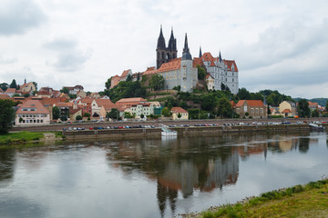 Naklejka na ściany i meble Gebäude am Wasser mit Burg und Kirche vor Hintergrund mit Wolken