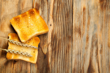 Toast bread in a wicker plate on wooden background. Top view