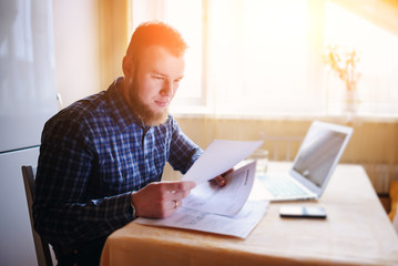 Handsome man doing some paperwork at home