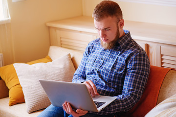 Young man working absorbed on laptop at home