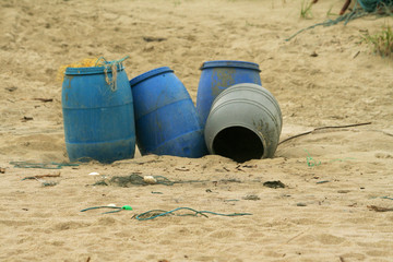 empty plastic barrels lying on the beach - fish, nets