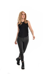 Fototapeta premium full length portrait of girl wearing black clothes and long leather jacket. standing pose in white background.
