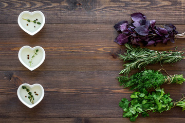 home cooking with fresh greenery and organic oil on wooden table background top view mock up
