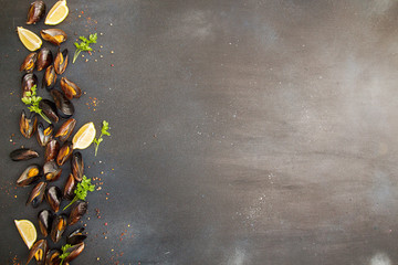Overhead of row of frilled mussels with lemon and parsley. Healthy food concept. Copy space.