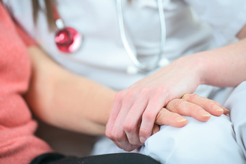 friendly female doctor hands holding patient