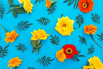 Fototapeta na wymiar Floral pattern made of flowers on blue background. Flat lay, top view. Floral background.