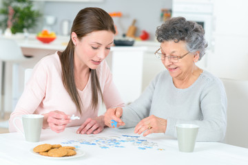 grand daughter and grand mother working on puzzle