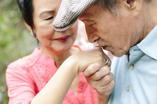 Tender moment of asian man kissing his sweetheart's hand