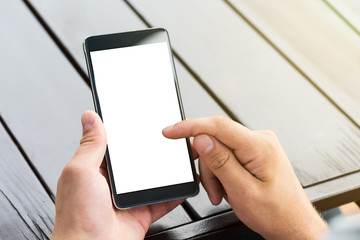 Man holding smart mobile phone on wooden table background