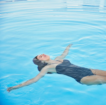 Beautiful woman in pool at luxury resort