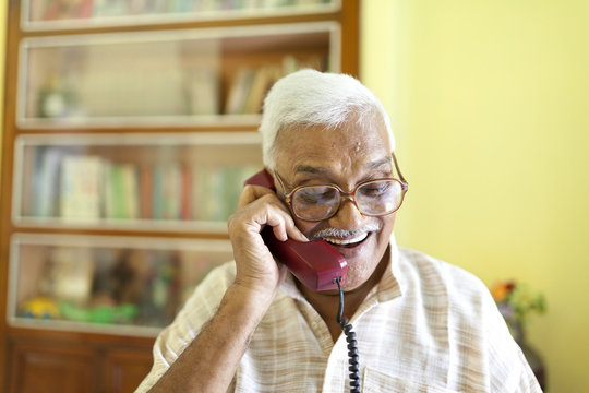 Senior man using vintage telephone