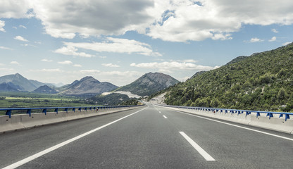 Highway outside the city receding into the highlands.