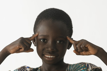 African ethnicity boy thinking with his fingers pointing to his head, isolated on white