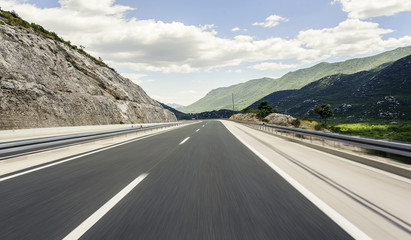 Highway outside the city receding into the highlands.