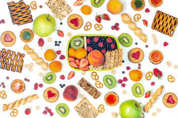 Lunch box and variety of fruits, berries and crunches on white background © lithiumphoto
