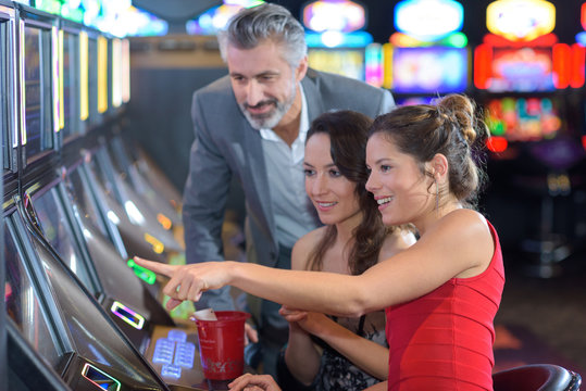 friends in casino on a slot machine
