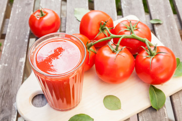 Tomatoes. Juice. On a cutting wooden board. Useful vegetables.