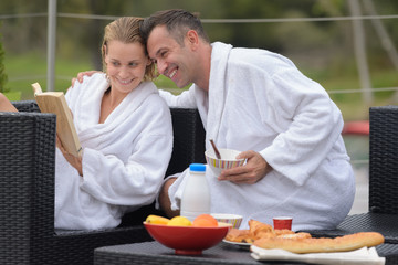 omantic couple reading book outdoors