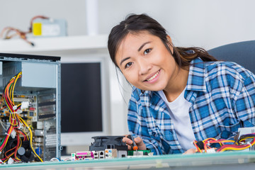 woman repairing an electronic component of a computer