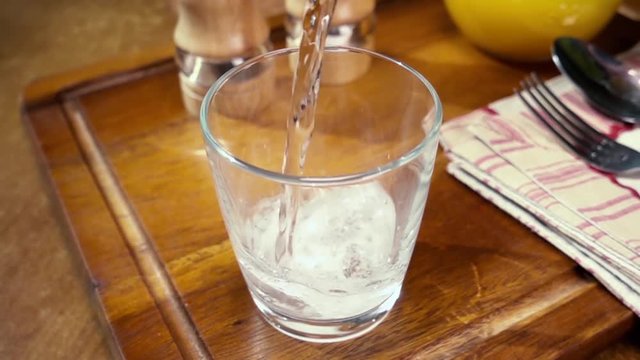 Mineral water pouring into a glass, the morning Breakfast, Slow motion with rotation tracking shot.