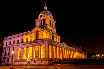 A night time image of the dome above the entrance of the Old Royal Naval College in Greenwich, London, England, United Kingdom, also showing the green laser line of the Greenwich Meridian GMT