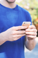 Latin man typing on his phone.