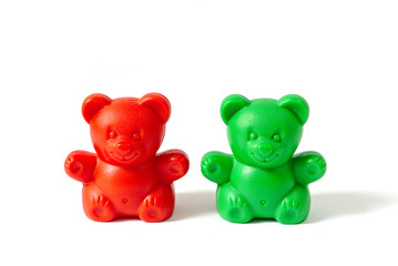 Red and green plastic toy bears isolated on white background