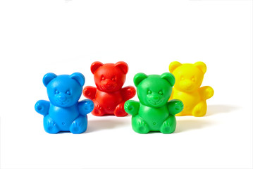 Blue, red, yellow and green plastic toy bears isolated on white background arranged in two rows
