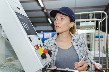 female manufacture employee holding clipboard and noting