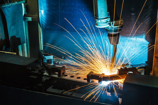 Worker, welding in a car factory with sparks, manufacturing, industry
