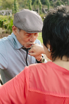 Senior asian man looking at his wife's wedding ring and kissing it