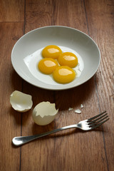 egg yolk with fork on wooden table