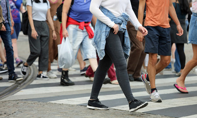people crossing the pedestrian crossing in the busy street of th